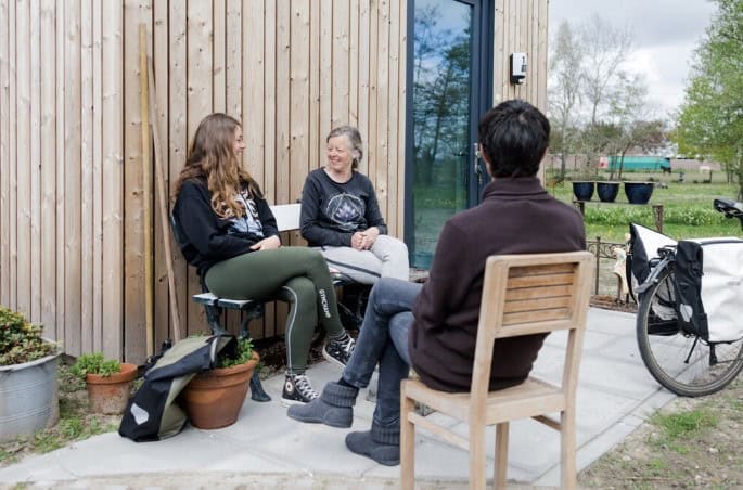 Ontspannende gesprekssituatie bij Laverhof, ouderen en vrijwilligers buiten in de tuin.